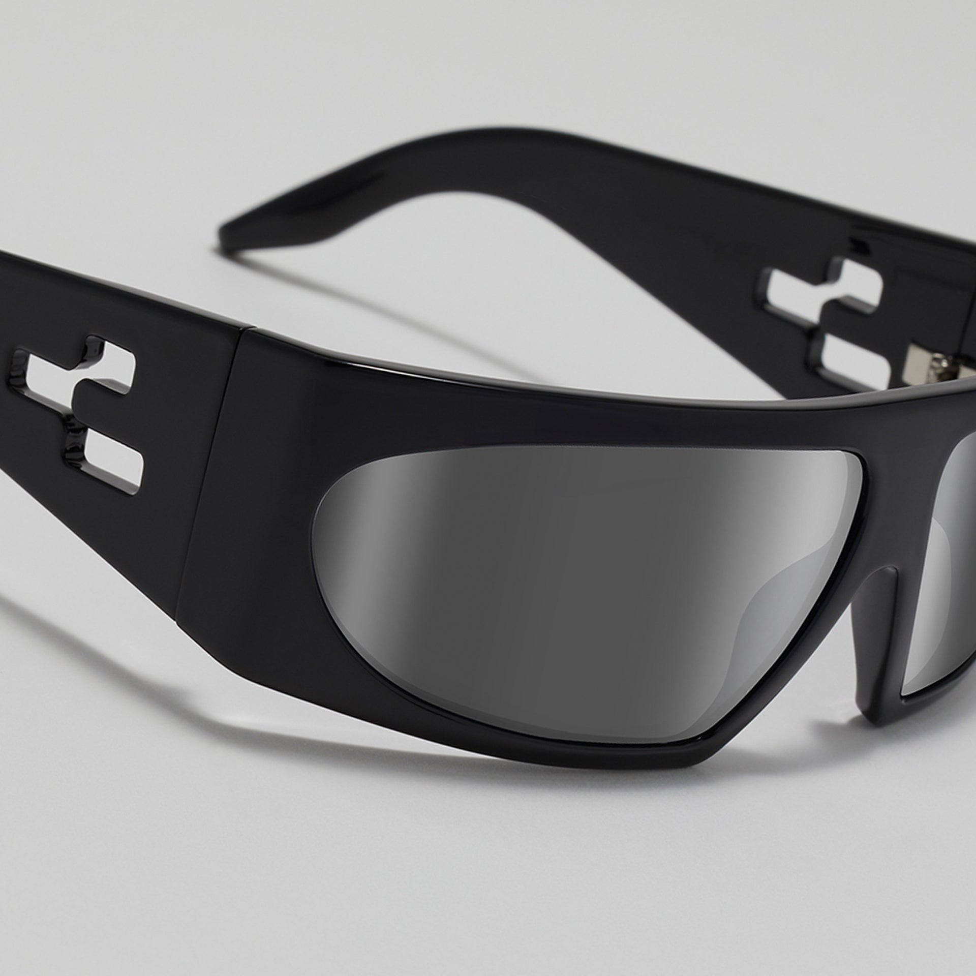 Black sunglasses with reflective lenses on a light gray background