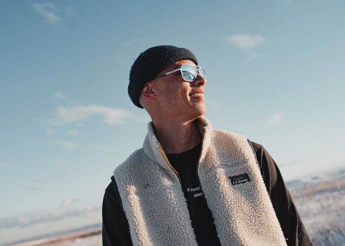 Man in a fleece vest outdoors in winter wearing Revo sunglasses