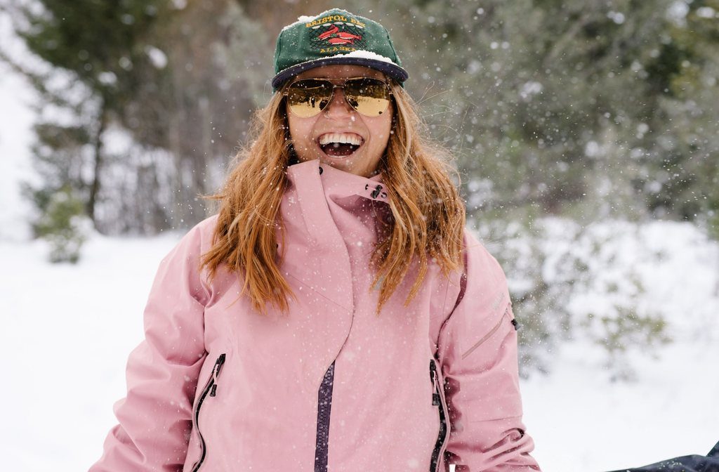 Woman laughing in the snow wearing Revo Relay sunglasses