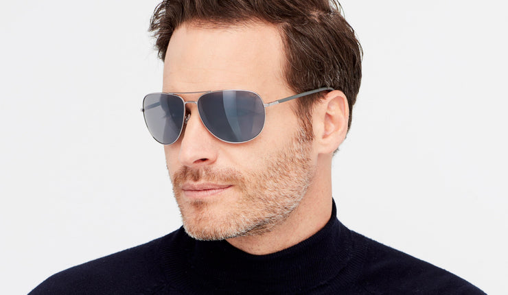 Man wearing polarized wrap aviator sunglasses with grey mirror lenses and chrome frames and black mockneck shirt